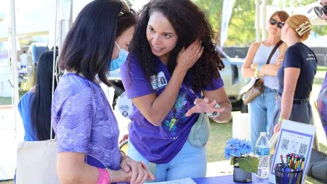 Mirella Diaz-Santos, PhD, speaks with a visitor at the Alzheimer’s Los Angeles "Making Memories Festival" at Los Angeles State Historic Park. 